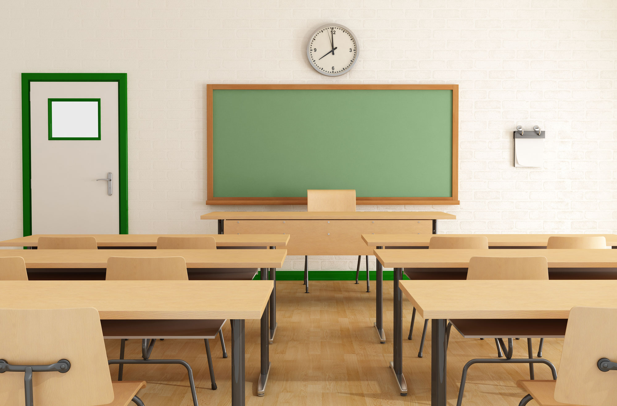 classroom with empty wooden desks and green chalkboard